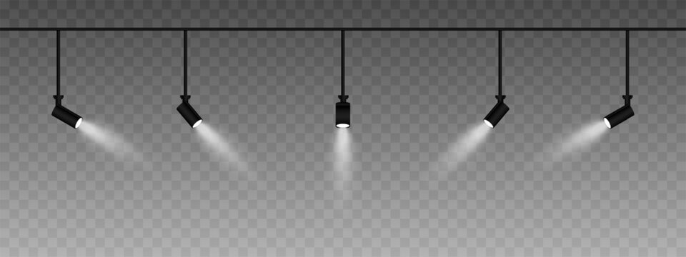 Row of adjustable spotlights emitting a soft white glow. Angled lights create a focused beam effect, adding ambiance to a dark background. Modern interior designs, exhibitions, and stage lighting