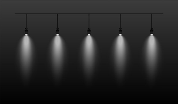 Row of white spotlights hanging from a track. Soft glow illuminating downward, creating a modern lighting effect. Ideal for stage lighting, exhibitions, and interior designs. Stage light