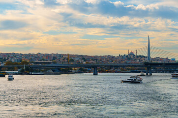 Fototapeta premium cityscape of Istanbul, Turkey, view to the Golden Horn Bay and architecture of city and ships and Bosphorus shore against the sunset sky, a popular tourist destination