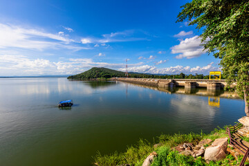 Natural background of clear sky, amidst the blue sky at the viewpoint, there are trees, sun, water retention dam, a nature stop for tourists.