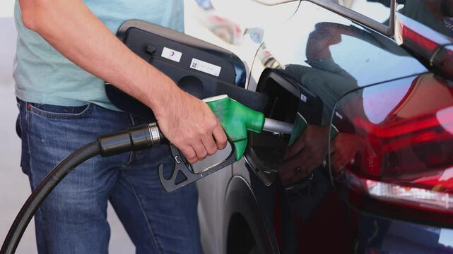 Man filling benzine gasoline fuel in car at gas station. Man refueling car.
