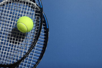 Tennis rackets and ball on color background