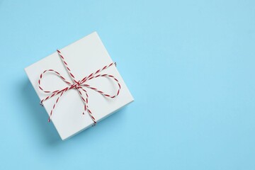 Beautiful gift box tied with bow on color background 