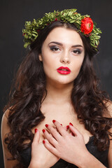 Fototapeta premium Glorious healthy female model with shiny hair, make-up and spring flower on black background