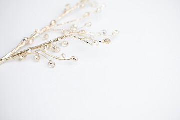Crystal beads on a golden branch on white background, Christmas concept