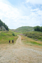 Two hikers in the mountains walking to the top. Mountain La Nuda, Appenino-Tosco emiliano, Emilia-Romagna, Italy