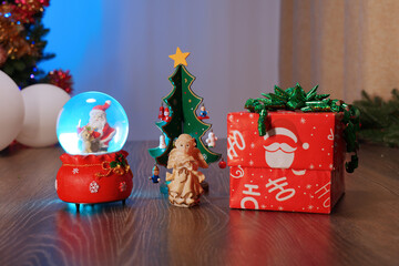 Glass ball. Christmas and New Year Gift Under the Tree with Garland and Ornaments. Christmas Decor Creating a Cozy Holiday Atmosphere.