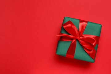 Beautiful gift box tied with bow on color background 