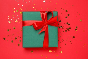 Beautiful gift box tied with bow on color background 