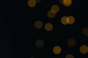 Golden blurred bokeh lights on black background. Glitter sparkle stars for celebrate. Overlay for your design