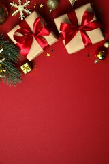 Beautiful gift boxes tied with bows and Christmas decorations on color background 