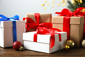 Beautiful gift boxes on the table with shining bokeh and Christmas tree behind