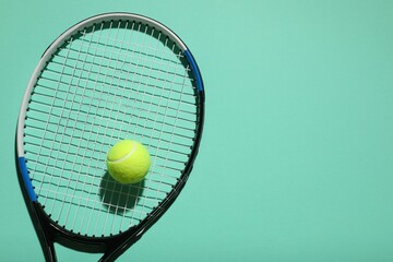 Tennis racket and ball on color background