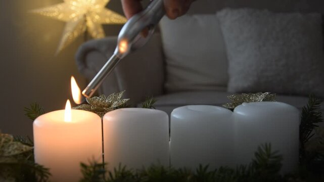 A woman lights four Christmas candles.