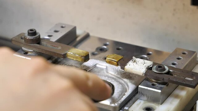 Slow-motion close-up of a machine carefully positioning endpieces on spectacle frames in a factory. Danyang, Jiangsu Province, China.