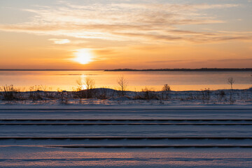 Landscape photo of Estonian nature in winter. Rails near the sea in Paldiski at sunset.