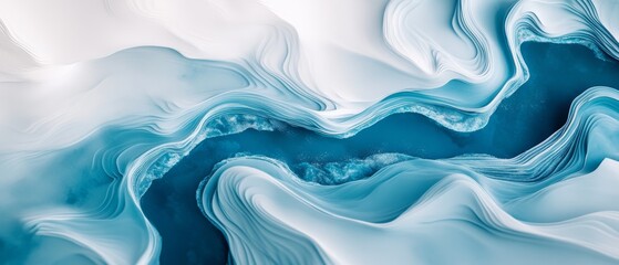 An aerial view of swirling blue and white waves forms an abstract, mesmerizing landscape reminiscent of icy rivers and snowdrifts.