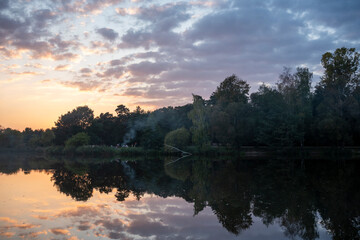 Obraz premium Sunset Over Serene Pond with Reflection and Reeds