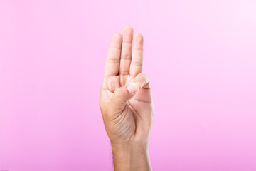 A hand displays various gestures, including a fist, open palm, and raised fingers, against a pink background. A visual exploration of communication through hand symbols