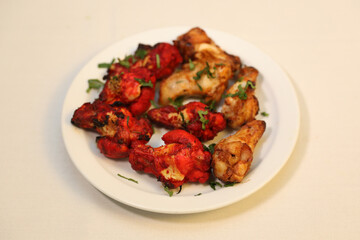 Dry grilled meats showcase marinated chicken with a vibrant red hue, garnished with fresh herbs.