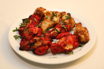 Dry grilled meats showcase marinated chicken with a vibrant red hue, garnished with fresh herbs.