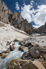 Long exposure river, stream. Glacial valleys and streams. Blue sky and snowy mountains. Snowy mountains of Tunceli. Pülümür Valley, Buyer Mountain, Sarıgül Plateau, Buyer Waterfall. Türkiye.