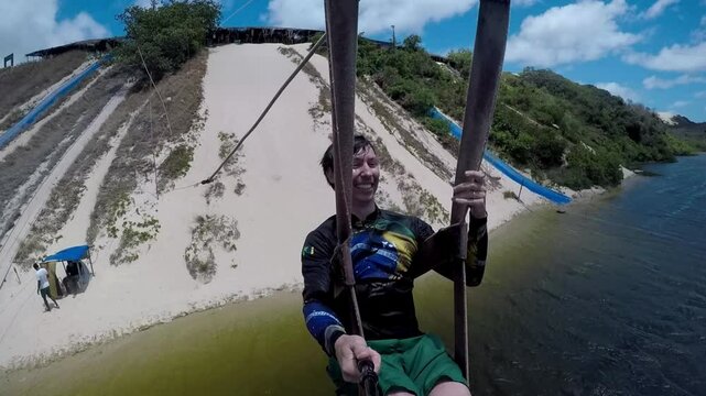 homem turista faz tiroleza em lago 