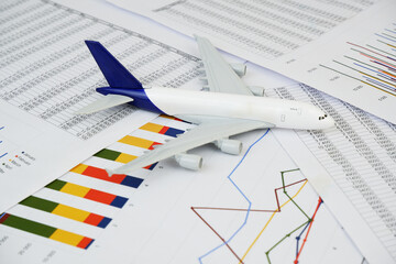 Airplane model on many financial reports. Cargo and shipping prices concept.