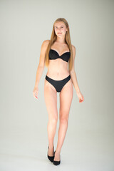 Fototapeta premium Close view of beautiful slim woman body in black underwear in the studio.
