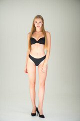 Fototapeta premium Close view of beautiful slim woman body in black underwear in the studio.