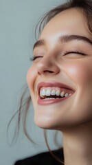 Obraz premium Portrait of a smiling woman with joyful expression, soft lighting.