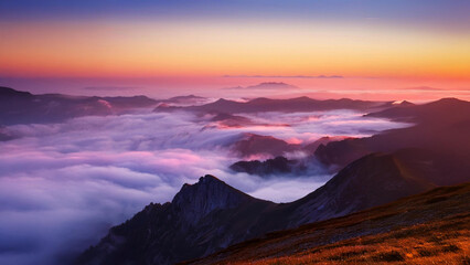 Fototapeta premium Mountain top at sunrise with fog rolling through the valley, casting a surreal pink and purple glow over the entire landscape