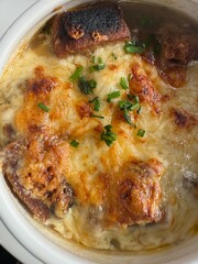 Top view of French onion soup garnished with parsley