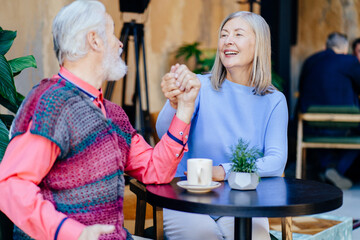 Elderly couple enjoying coffee at a cozy outdoor cafe
