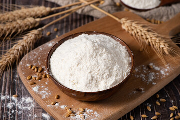 wheat flour and wheat ears on wooden table