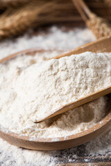 wheat flour and wheat ears on wooden table