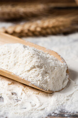 wheat flour and wheat ears on wooden table