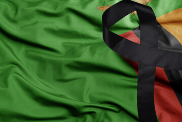 waving national flag of zambia with black mourning ribbon .tragedy concept