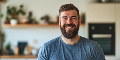 Obraz premium A Caucasian adult male with a beard stands happily at home during the day, with space available for text.