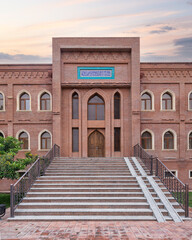 Naklejka premium Entrance of the stunning Imamzadeh Kompleks, or Complex in Ganja, Azerbaijan showcases beautiful architecture surrounded by lush greenery, inviting visitors to explore its rich history before sunset