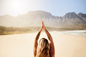 Beach, back and woman with yoga, meditation and hands together with adventure, wellness and chakra. Peaceful, person and girl with ocean, nature and pilates with routine, zen and healthy athlete