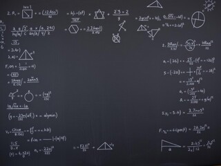 A vintage blackboard covered in complex scientific formulas and calculations in physics and mathematics, perfect for educational and creative projects, design, formulas