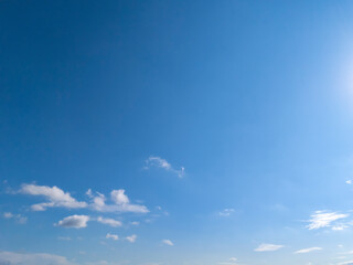 A beautiful clear blue sky with scattered clouds and bright sunlight. Perfect for backgrounds or nature-themed projects.