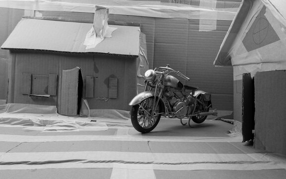 Historisch, Oldtimer, Motorrad Model, &auml;hnlich einer Harley Davidson, in Karton Modell-Landschaft in Schwarz Weiss