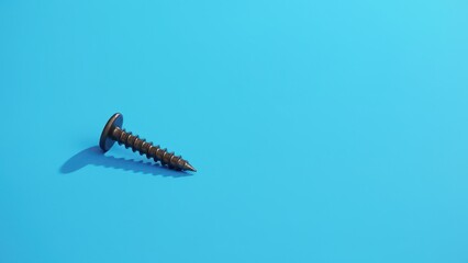 Screws and bolts for furniture repair. A single silver screw lies on a smooth blue surface, capturing a minimalist vibe with its metallic sheen and sharp threads.