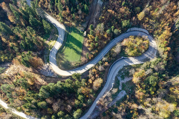 Bird's Eye View of Curved Winding Asphalt Road Through Forest Landscape