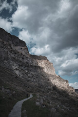 A solitary person is walking in the background views of the ancient cave mountain city Vardzia