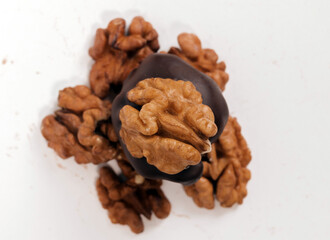chocolate pieces with almond or walnut over in box or on table,one over another in pyramid.sweets candy on white surface,free space for text, ready for chocolate business or factory.
