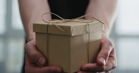 young man show brown craft paper gift box