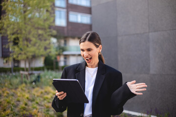 Happy delighted satisfied business woman with ponytail looking tablet gesturing yes winning wow...